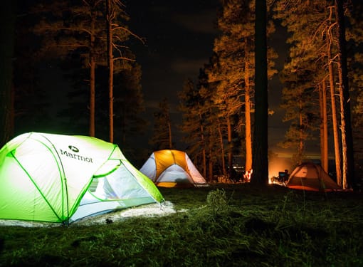 tentes dans campement avec feu de bois